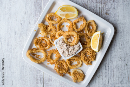 Fried Crispy Calamari Squid Rings with Tartar Sauce and Lemon.