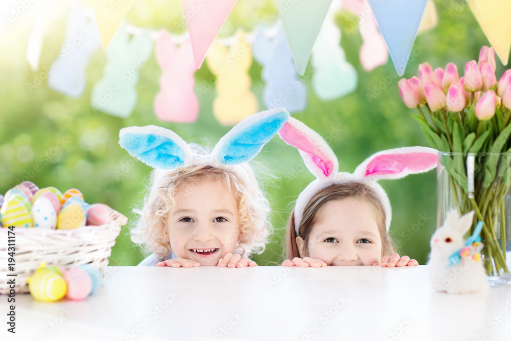 Naklejka premium Kids with bunny ears and eggs on Easter egg hunt.