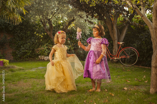 Children in princess costumes playing in the garden. Outdoors. © Susana Valera