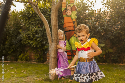 Kids with costumes playing in the garden. Outdoors.