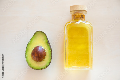 Fresh Avocado and oil in bottle on wooden background