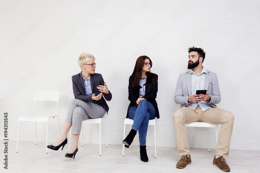 Obraz premium Three people talking to each other while waiting for job interwiev