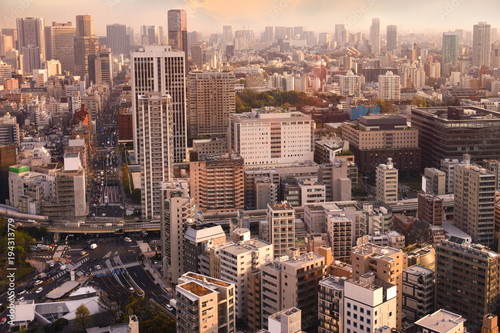 Obraz premium Cityscapes of Tokyo sunset, city aerial skyscraper view of office building and downtown and street of minato in tokyo with yellow sunlight background. Japan, Asia