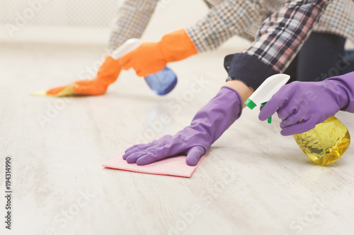 Young unrecognizable couple washing floor together