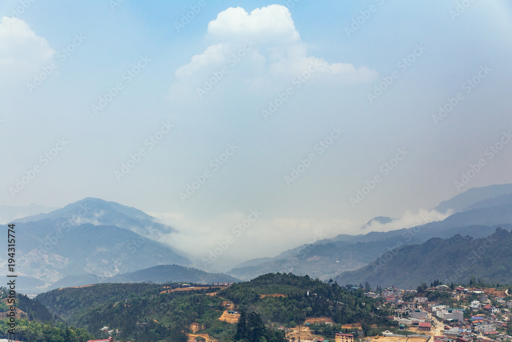 Sa Pa landscape with city, mountains, fog and trees the view from above from Sam Bay Cloud Yard in summer at Ham Rong Mountain Park in Sa Pa, Vietnam.