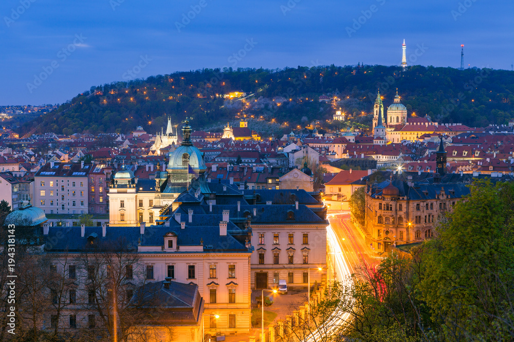 Old town and Petrin hill illuminated night view from Letenske garden. Prague, Czech Republic