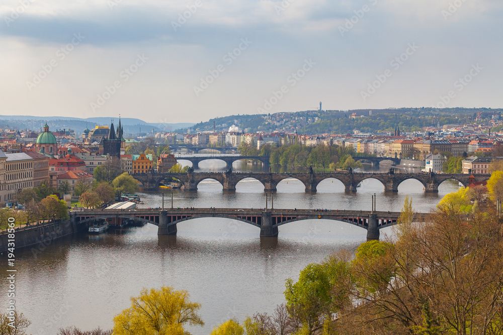 Remarkable view of Prague bridges over Vltava river with historic embankment. Daytime, spring season, green park at the foreground