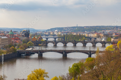 Remarkable view of Prague bridges over Vltava river with historic embankment. Daytime, spring season, green park at the foreground photo