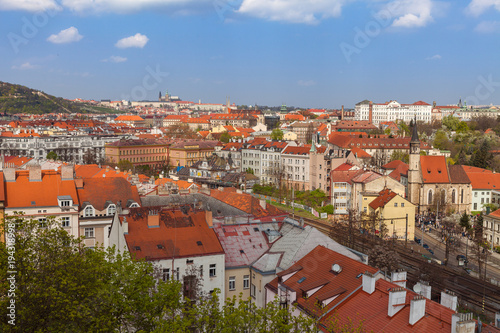 Prague skyline with castle and living blocks red rooftops with park and trees