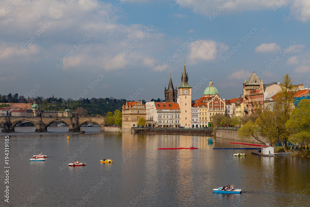 Naklejka premium Widok na Wełtawę z łodziami. Stare Miasto w Pradze, Czechy, sezon letni.