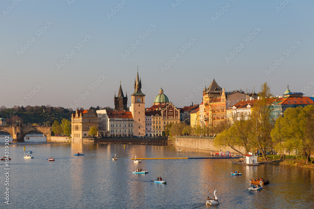 Old town of Prague, Czech Republic, summer season. View on the river Vltava with boats and happy tourists