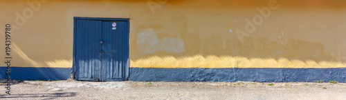 yellow wall with blue doors close up