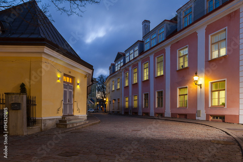 Old Tallinn architecture ensemble. The narrow street illuminated at the evening.