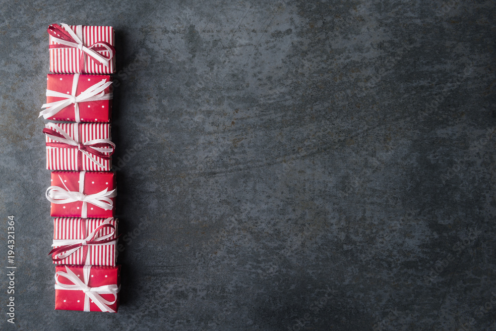 Fototapeta premium Red gift boxes on dark stone background with copy space.