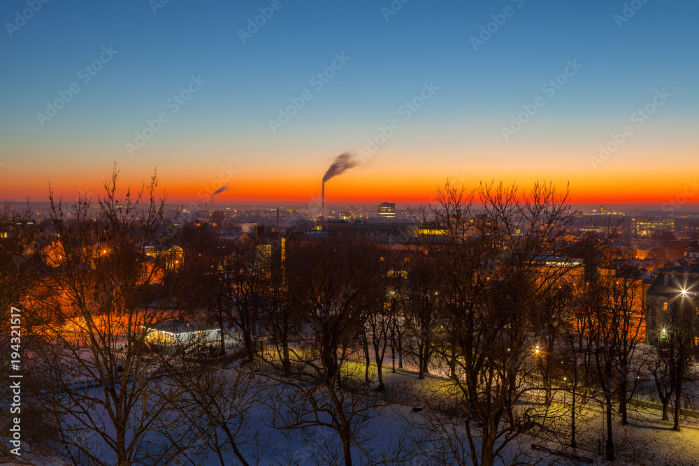 Exciting winter view of night old town of Tallinn. Aerial over park and industrial distrinct