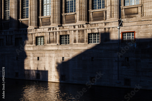 Old building wall in the water of a river with shadows. Classic architecture of Berlin, Germany.