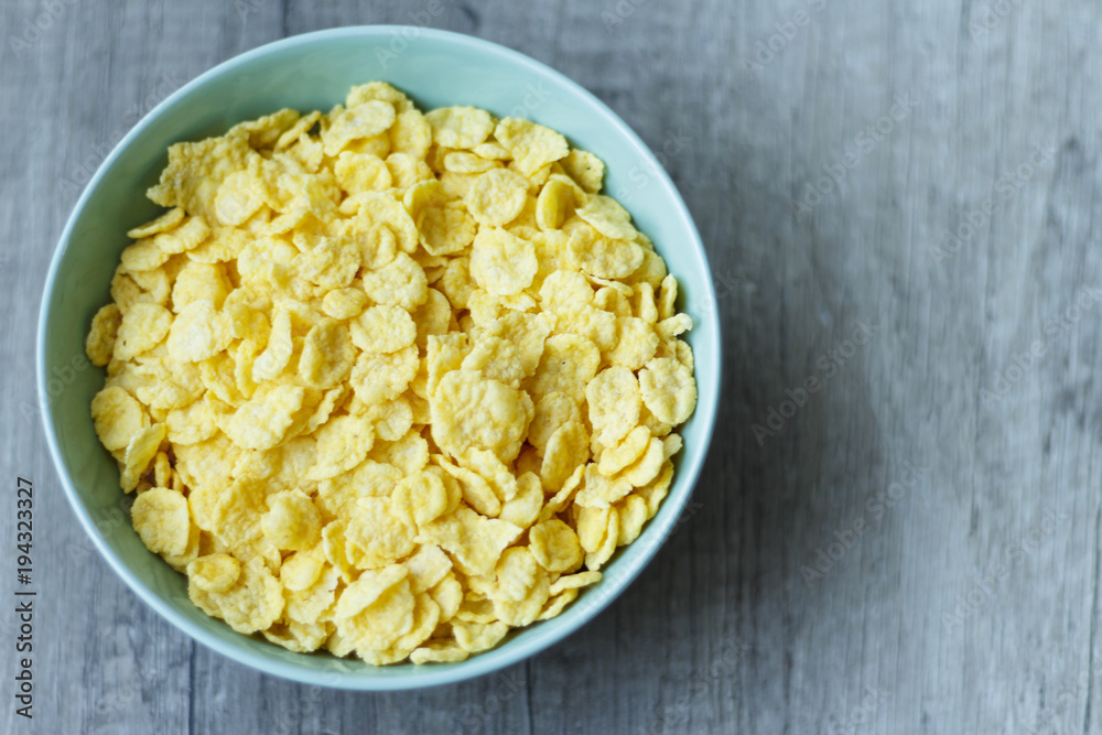 flakes lie on a green plate that stands on a wooden table, breakfast, in the photo there is a place under the text flakes lie on a green plate that stands on a wooden table, breakfast, in the photo there is a place under the text