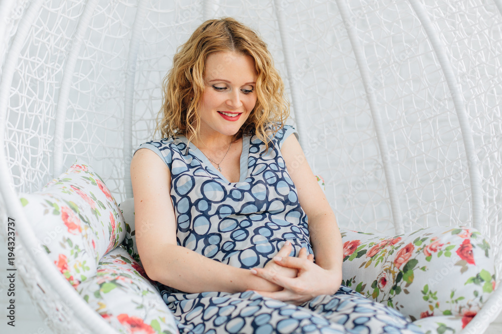 beautiful Pregnant  woman sits on swing at home