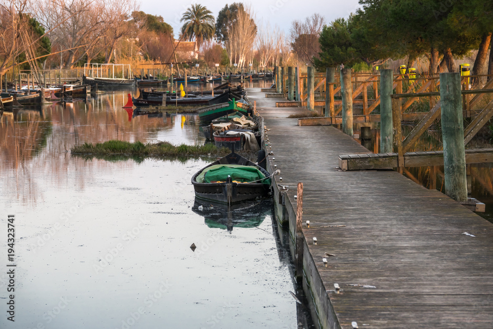 Obraz premium several traditional wooden boats on the mooring dock. harbor of the Albufera nature reserve, Catarroja Valencia Spain
