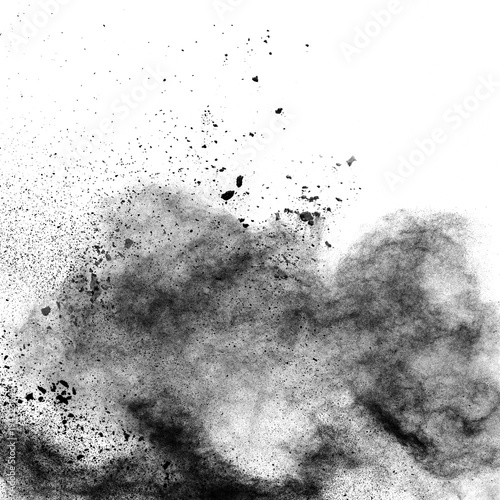 Black powder explosion against white background.The particles of charcoal splatted on white background. Closeup of black dust particles explode isolated on white background.