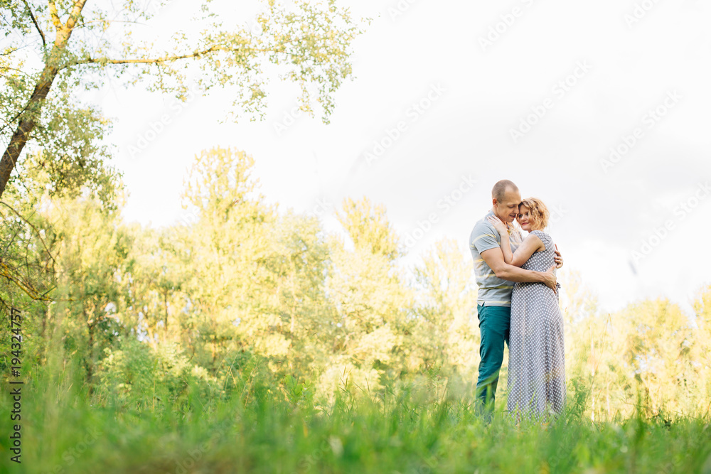 Horizontal portrait of a husband hugging his beautiful pregnant wife