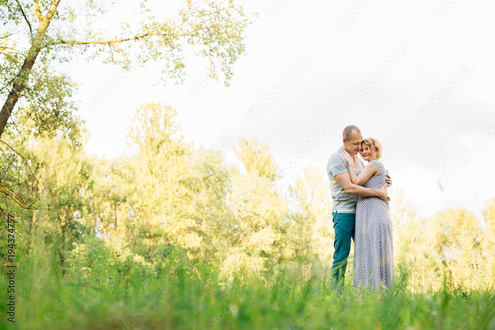 Horizontal portrait of a husband hugging his beautiful pregnant wife Horizontal portrait of a husband hugging his beautiful pregnant wife