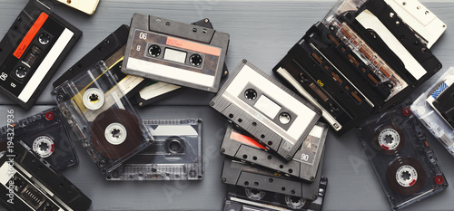 Canvas-taulu Heap of vintage audio cassettes at gray planks background