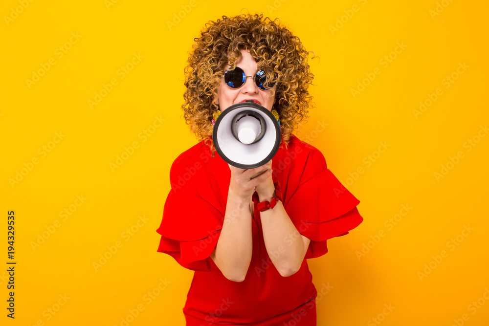 Fototapeta premium Attractive woman with curly hair with loudspeaker