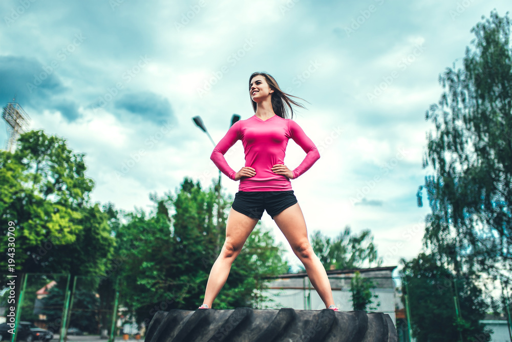 Pretty sporty girl workout outdoor with big tire Pretty sporty girl workout outdoor with big tire