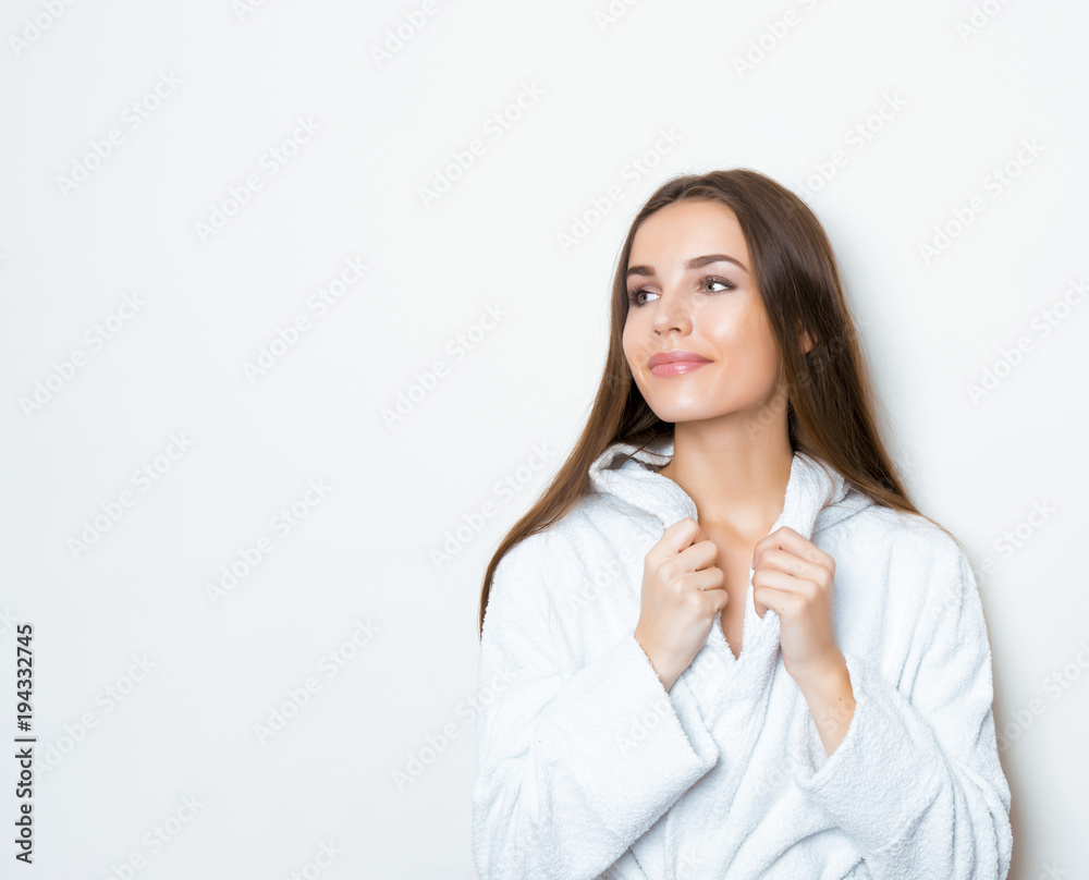 beautiful young woman with long hair wearing bath robe and posing on grey background with copy space beautiful young woman with long hair wearing bath robe and posing on grey background with copy space