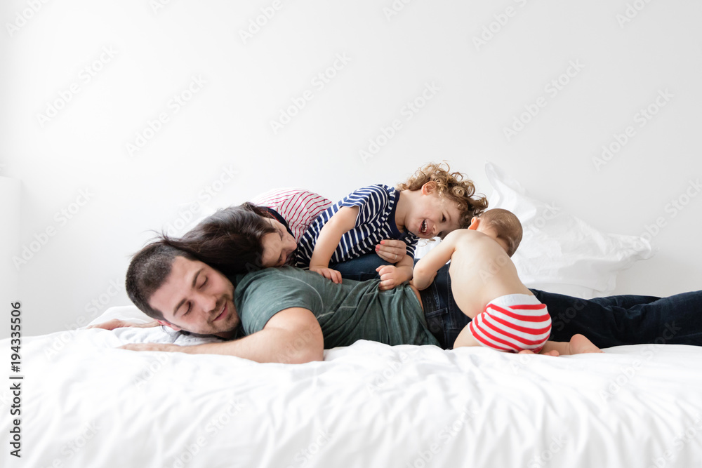 Family of four cuddling on bed Family of four cuddling on bed