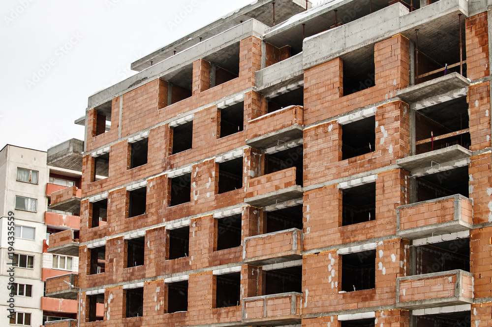Residential solid building house under construction in red bricks shell Residential solid building house under construction in red bricks shell