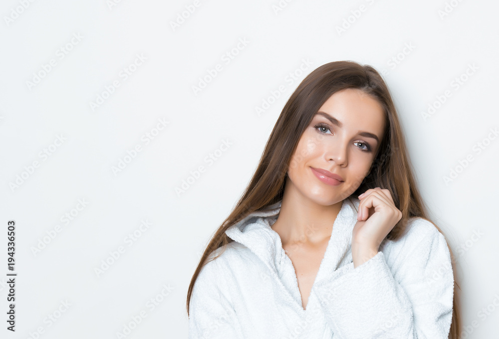 beautiful young woman with long hair wearing bath robe and posing on grey background with copy space beautiful young woman with long hair wearing bath robe and posing on grey background with copy space