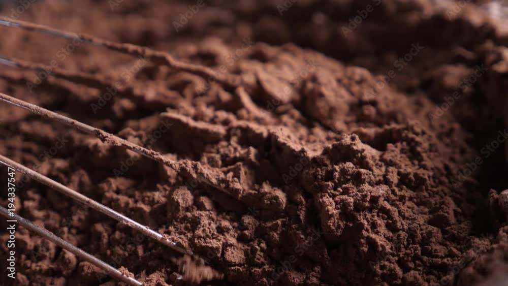Mixing of the solid rolling cocoa powder, highlighted, slow motion( macro close up) Mixing of the solid rolling cocoa powder, highlighted, slow motion( macro close up)