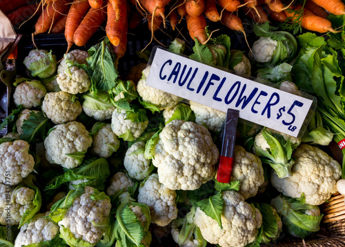 Cauliflower and carrots for sale at a farmers market.