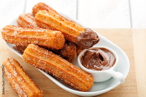 Churros with sugar and chocolate sauce . top view  photo
