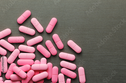 Pink medicine pills on a grey background