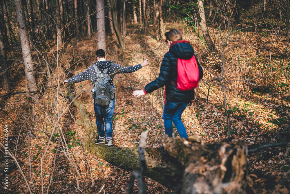 Father and daughter crossing over old tree log Father and daughter crossing over old tree log