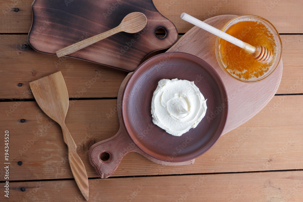 Sour cream, cream, fresh sour cream in pottery on a wooden background, dairy products and honey, wooden board, French breakfast, healthy food, sour cream and honey in a rustic style, minimalism, copy 