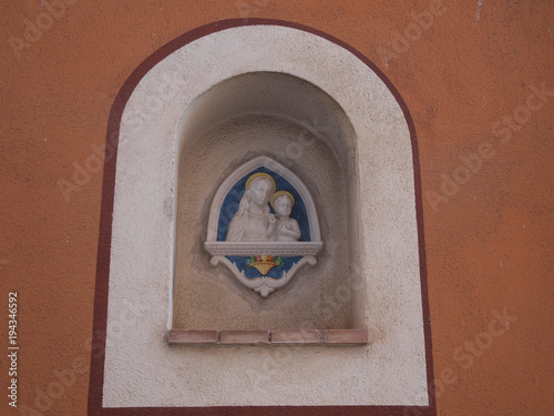 close-up of traditional madonna with child enchased on facade wall in mediterranean region photo