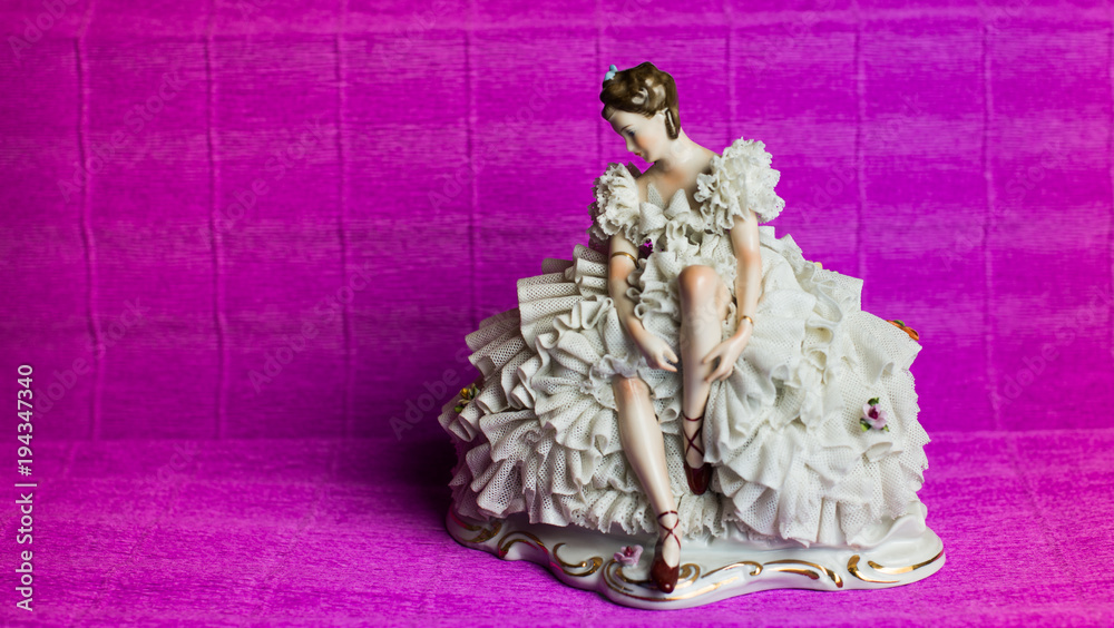 statuette of a ballerina on a pink background