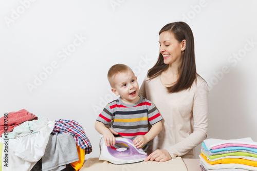 Little boy, woman ironing family clothing on ironing board with iron. Son help mother with housework isolated on white background. Encouraging Autonomy in children concept. Parenthood, child concept.