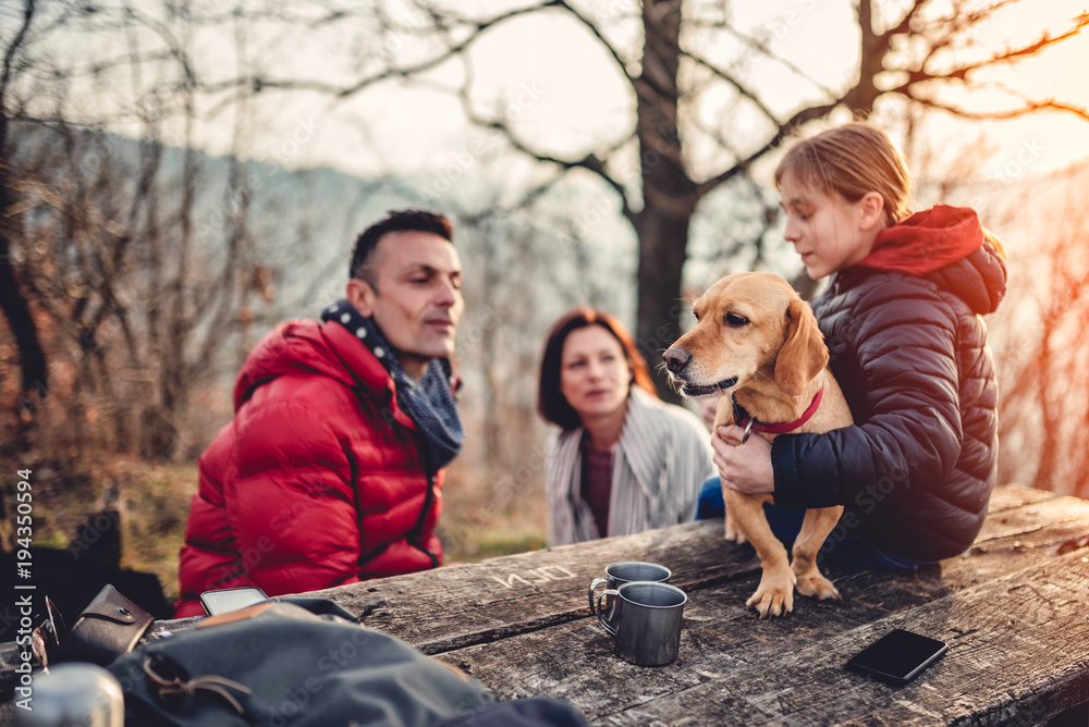 Dog sitting at a picnic table with owners Dog sitting at a picnic table with owners