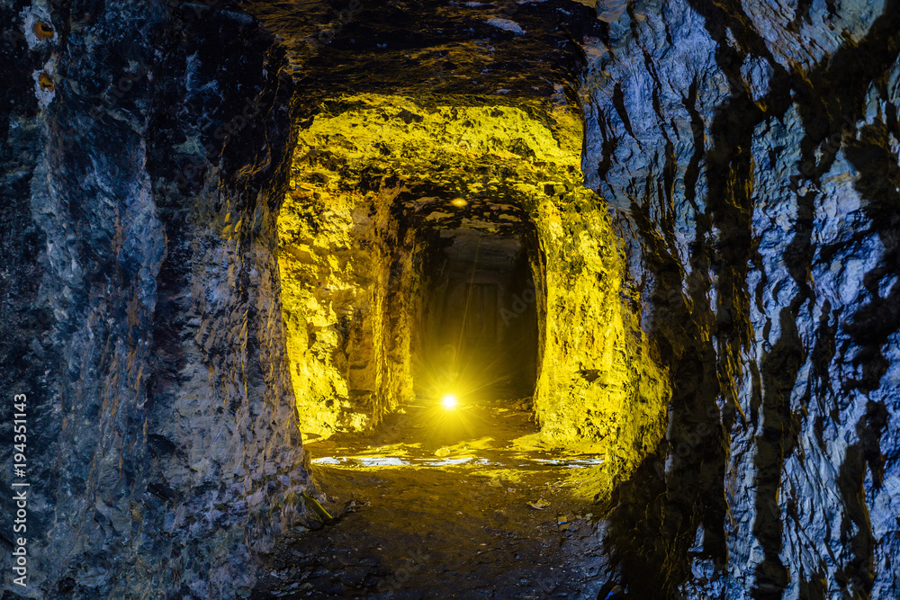 Fototapeta premium Abandoned and collapsed sandstone or limestone mine illuminated by color lights