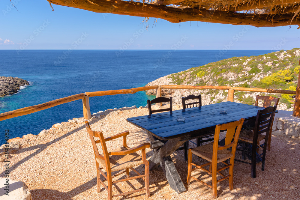 Greek tavern on cliff with view of blue sea water. Zakynthos island. Zante, Greece