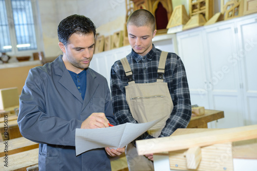boss and apprentice working in a carpenters workshop