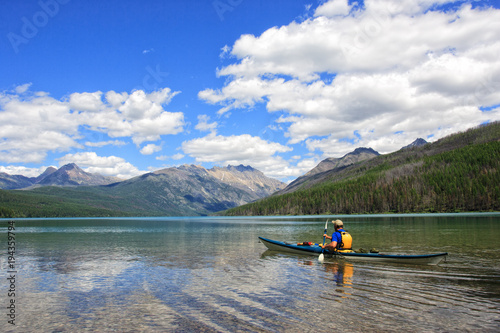 A man kayaking in a glacier-fed lake in North Montana right on the Canadian border.