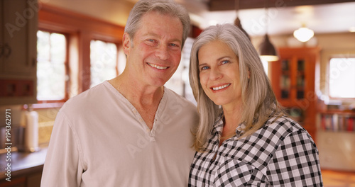 Beautiful white senior couple smiling together indoors