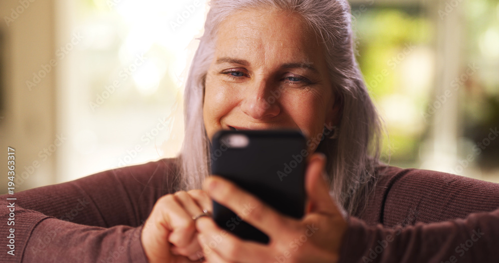 Mid aged white woman texting on a cellphone device Mid aged white woman texting on a cellphone device