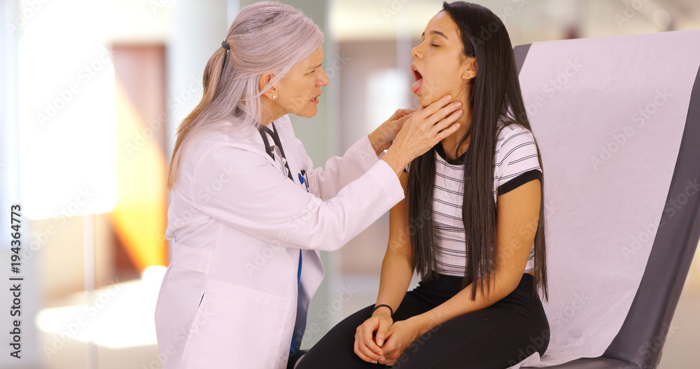 Obraz premium An older doctor gives a girl an annual check up. A young girl recieves a medical check-up